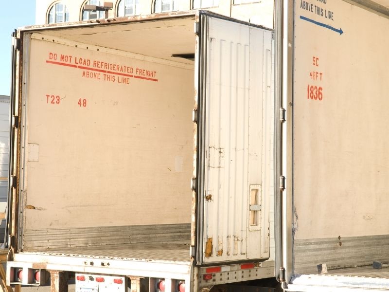 Un camión refrigerado transporta alimentos donados hacia un centro de acopio.