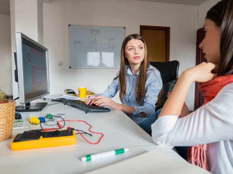 dos mujeres que trabajan en una oficina ofreciendo atención a proveedores y comunidades