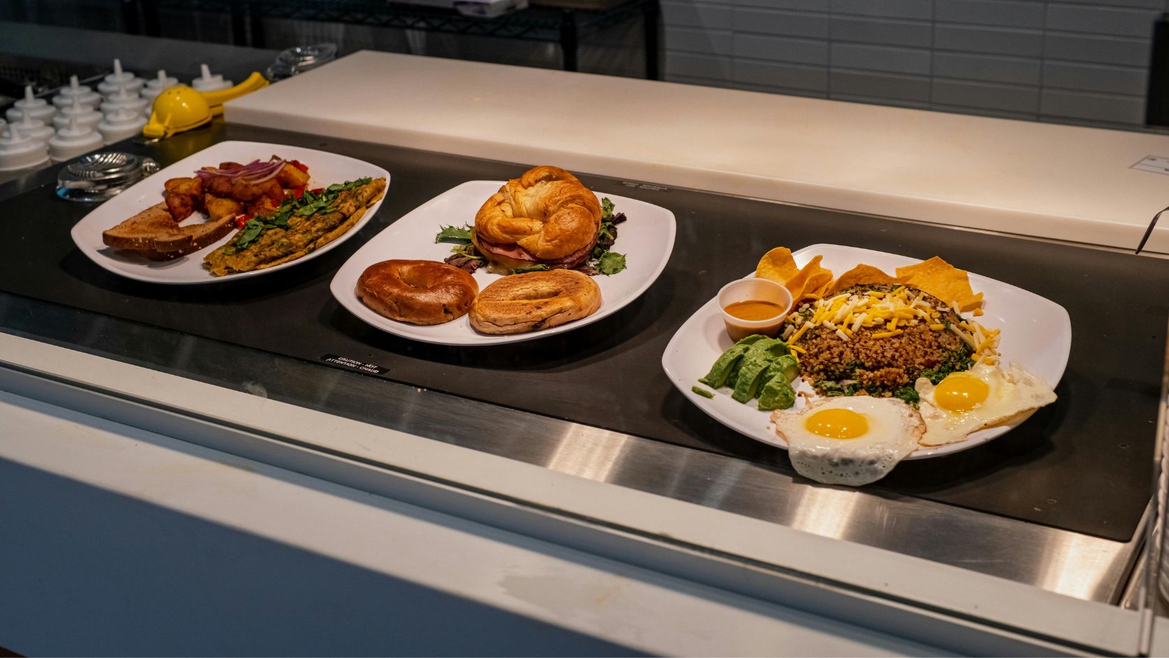 Tres platos con diferentes preparaciones y guarniciones en la barra de un restaurante, representando la diversidad de opciones en los menús.
